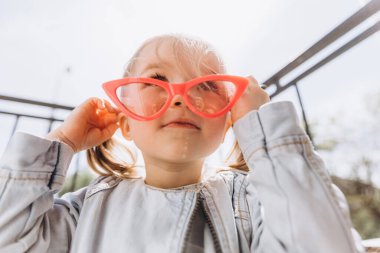 Samimi çocukların gülüşü ve eğlencesi, gülümseyen kız oynuyor ve fotoğraf için poz veriyor.