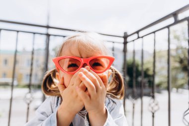 Samimi çocukların gülüşü ve eğlencesi, gülümseyen kız oynuyor ve fotoğraf için poz veriyor.