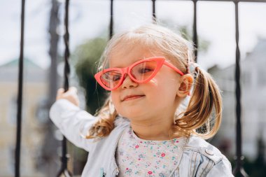 Samimi çocukların gülüşü ve eğlencesi, gülümseyen kız oynuyor ve fotoğraf için poz veriyor.