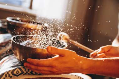 Masörlü bir spa ve Tibet müzik kaseleriyle rahatlatıcı bir masaj yapan bir müşteri.