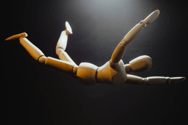 Uçan bir adamın ahşap modeli, bir adamın tepeden tırnağa düştüğü izlenimi.