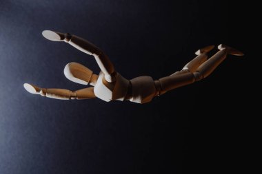 Uçan bir adamın ahşap modeli, bir adamın tepeden tırnağa düştüğü izlenimi.