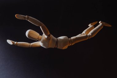 Uçan bir adamın ahşap modeli, bir adamın tepeden tırnağa düştüğü izlenimi.