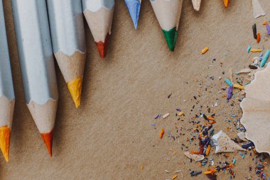 Resim atölyesi veya resim ve güzel sanatlar dersi için arka plan: Keskin renkli kalemler ve çizim kağıdındaki talaşlar