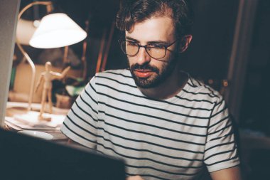 Modern genç adam geceleri evden uzakta çalışıyor. Gündelik milenyum adamı bilgisayarında daktilo yazıyor. İnternette geziniyor. Ekrana bakıyor ve uzak işten keyif alıyor.