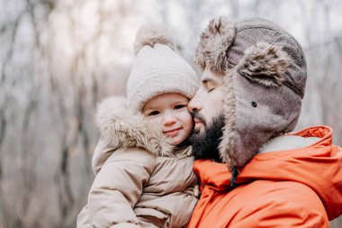 Mutlu aile portresi: baba ve küçük kızı parkta kış tatilinde. Mutlu, neşeli bir aile.