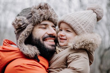 Mutlu aile portresi: baba ve küçük kızı parkta kış tatilinde. Mutlu, neşeli bir aile.
