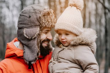 Mutlu aile portresi: baba ve küçük kızı parkta kış tatilinde. Mutlu, neşeli bir aile.