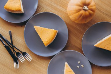 Masanın üzerinde balkabağı keki dilimleri olan bir sürü tabak var. Düz konum, instagram biçimi