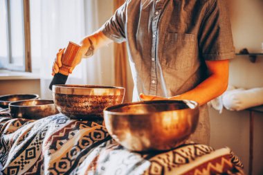 01.06.2020 Ukrayna, Vinnytsia: elinde bakır Tibet kâsesi olan sakallı bir adam. Tibet kâseleri kullanılarak yapılan meditasyon masajı.