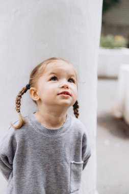 Samimi çocukların gülüşü ve eğlencesi, gülümseyen kız oynuyor ve fotoğraf için poz veriyor.