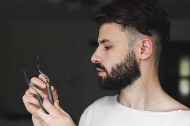 Elinde sanatsal aletler olan ve resim yapmaya hazırlanan sakallı bir adamın portresi.