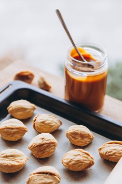 Masa arkasında kaynatılmış konsantre süt olan ev yapımı kurabiyeler. Boşluğu kopyala