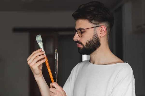 髭を生やした男が道具を持っていて絵を描く準備をしている姿を — ストック写真