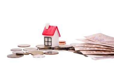 Beyaz arka planda kırpma yolu olan bir ev almak için para biriktirmek için bir yığın para ve ranza..