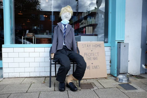 Scarecrow of UK Prime Minister Boris Johnson sitting outside hair salon with sign about the Coronavirus Covid-19 lockdown