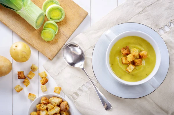 Leek and potato soup with croutons on white wooden table, top view. — Stock Image Leek Potato Soup Croutons White Wooden Table Top View Stock Photo