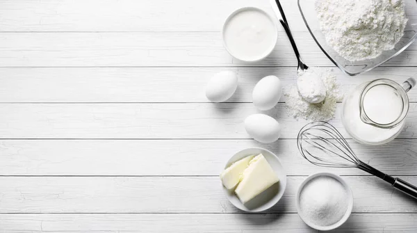 Cooking tools and ingredients from above. Baking concept with measuring  spoons, wooden scoops, whisks, cookie cutters, sugar, flour, eggs and  cinnamon on a modern concrete background with copy space Stock Photo