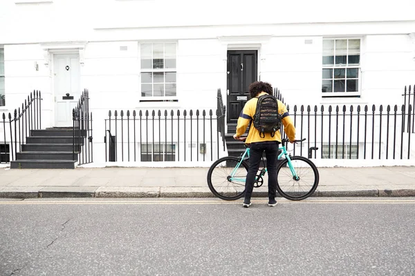 Millennial on bike in urban area. Fixed gear bike in a suburb of London.
