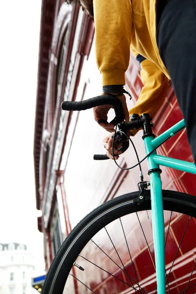 Millennial on bike in urban area. Front wheel fixed gear bike in a suburb of London.