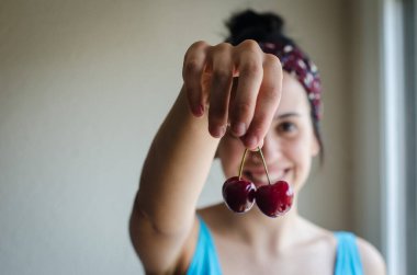 Genç kız taze kiraz tutuyor..