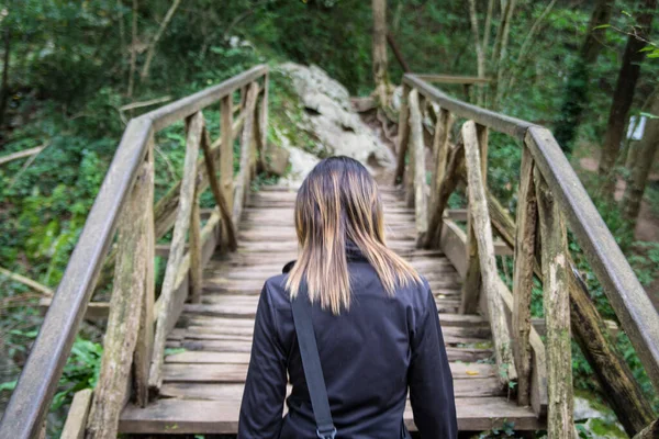 Νεαρή Κοπέλα Διασχίζει Μια Ξύλινη Γέφυρα Στο Δάσος Φωτογραφία Αρχείου