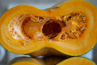 Dilimlenmiş yarım kabak ve yakın plan tohumlar.