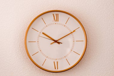 Homojen arka planda duvardaki altın saat