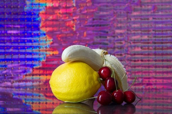 Früchte Auf Dem Spiegel Bananen Kirsche Zitrone Mit Farbigem Hintergrund — Stockfoto