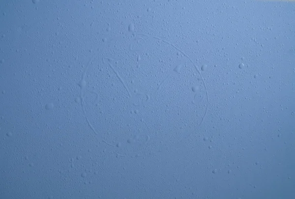Drops of water in the form of a clock on a blue background