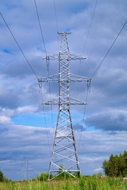 Mavi gökyüzüne karşı kablolu elektrik direği. Metal yapının doğru biçimi