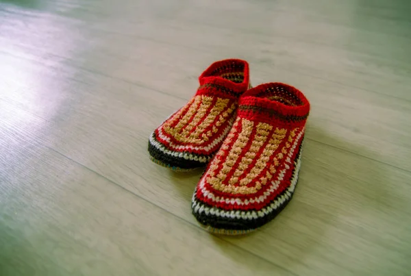 Red knitted wool slippers close-up stand on the floor