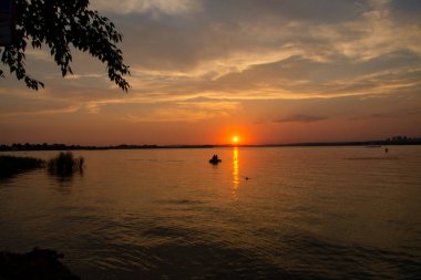 Güneş şehir göletinin üzerinde batıyor. Gün batımında gölet, güneş parıldıyor.