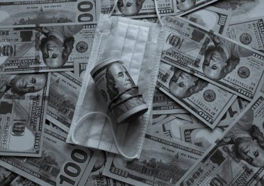 Banknotların üzerinde beyaz bir Covid 19 maske var. Coronavirus maskesi banknotların üzerinde yatar