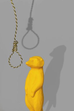 Sarı mirket heykelciği ile gri arka planda cellat