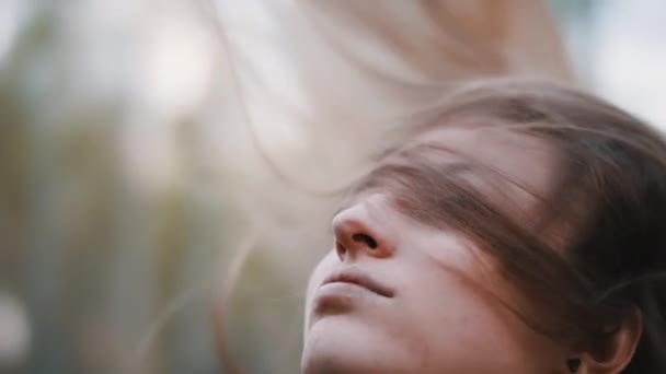 Giovane bruna che sale sulla testa mentre i capelli lunghi rimangono sul suo viso. Colpo al rallentatore da vicino. Bellezza naturale — Video Stock