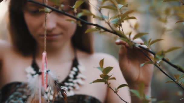 Junge schöne und geheimnisvolle Frau, die Traumfänger im Wald spinnt. Zeitlupenschuss — Stockvideo
