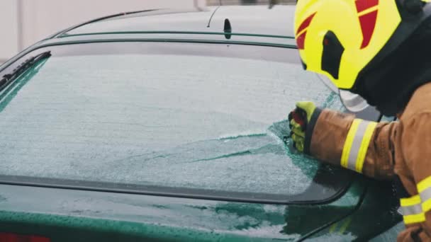 Redding van een auto-ongeluk, brandweerman die het glas van de auto brak. close-up, slow motion shot — Stockvideo