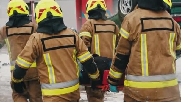 Tűzoltók mentik meg a sérültet az autóbaleset után. Lassú mozgás. — Stock videók