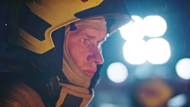 Ritratto di un pompiere in azione in uniforme con luce intensa sullo sfondo. Addestramento vigili del fuoco — Video Stock