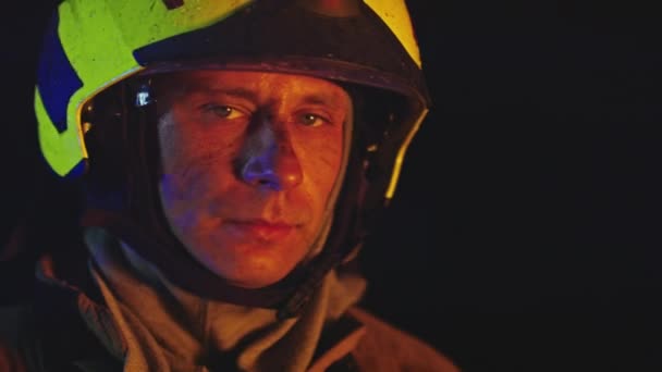 Retrato de un bombero en acción en uniforme completo con luz brillante en el fondo. Entrenamiento de petardos — Vídeos de Stock