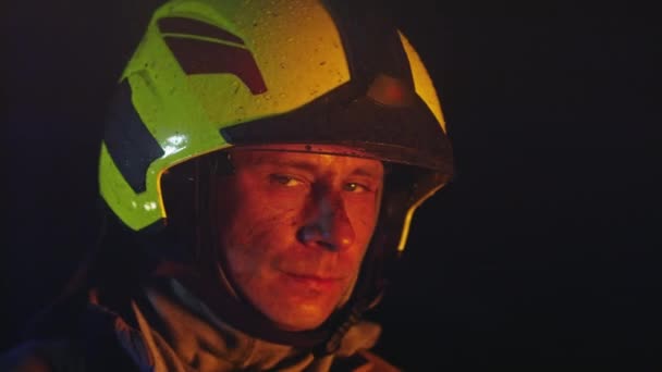 Retrato del héroe bombero con casco durante la acción. Movimiento lento — Vídeos de Stock