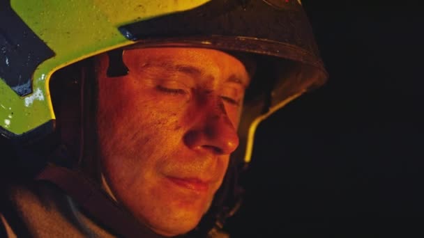 Portrét hasiče v akci v plné uniformě. Otočil hlavu, aby se podíval směrem ke kameře. Školení Firefigters — Stock video