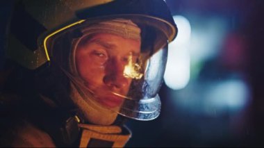 Üniformalı bir itfaiyecinin portresi. Kafasını kameradan çeviriyor. Yüz ifadesi