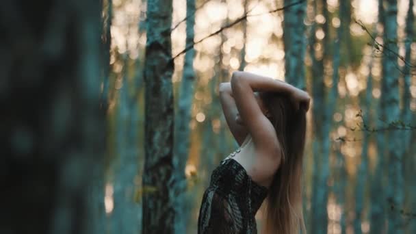 Молода біла жінка, брюнетка грає з довгим волоссям у лісі. Концепція природної краси, повільний рух — стокове відео