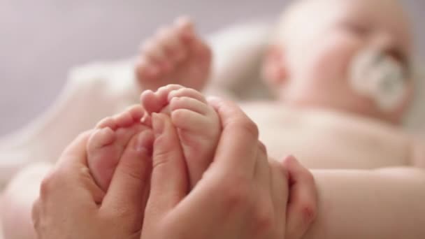 Mãe massagear e cócegas pequenos pés de bebê. close up slow motion shot — Vídeo de Stock