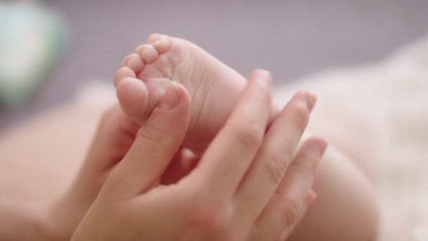 Mãe massagear e cócegas pequenos pés de bebê. close up slow motion shot — Vídeo de Stock
