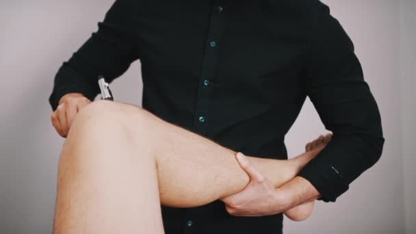 Kiropraktisk behandling - Läkare specialist testa reaktionen på medicinsk hammare på ett knä. Reflex-kontroll — Stockvideo