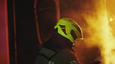 İtfaiyeci yanan kapıyı kırıyor. Yavaş çekim.