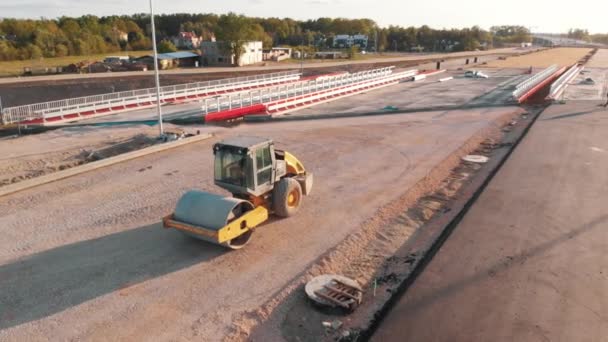 新しい道路建設日没の間のアスファルト舗装機と蒸気道路ローラー — ストック動画